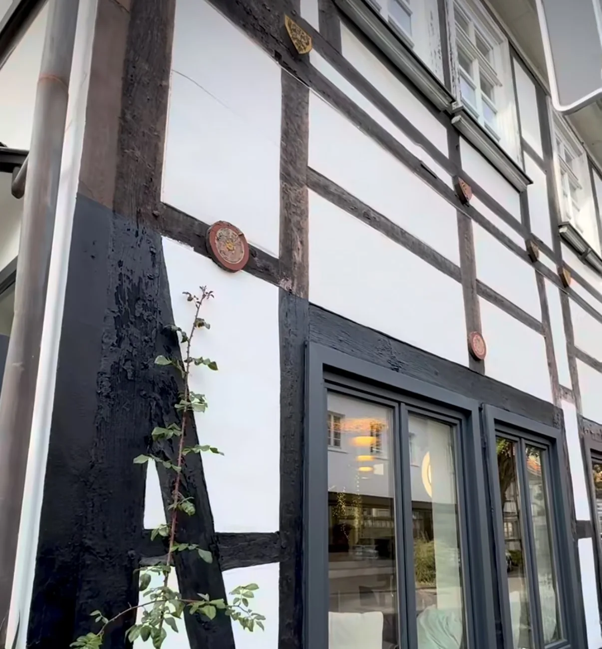 Die schwarz-weiße Fachwerkfassade des K3 mit Tisch und Stuhl davor